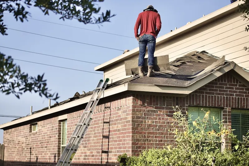 Professional roofer working on a residential roof in Howland